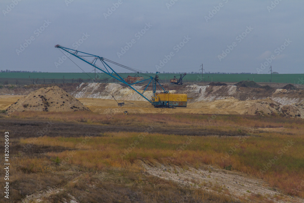 A powerful dragline excavator works in a clay quarry