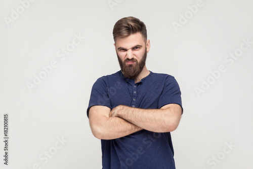 Resentful man, with arms folded, over gray background