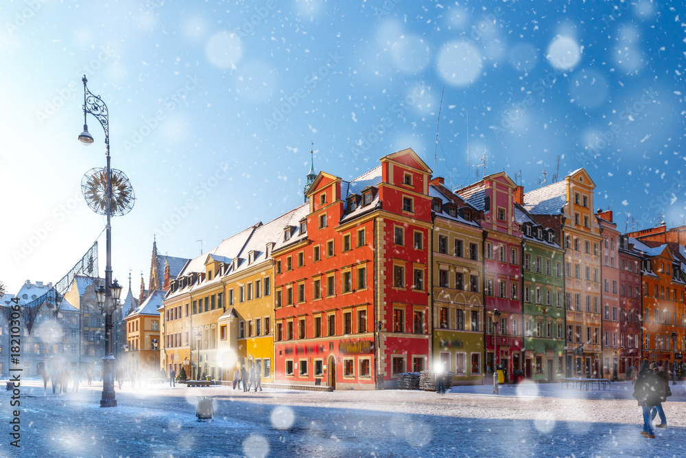 Fototapeta premium Multicolored traditional historical houses on Market square in the winter snowy morning, Old Town of Wroclaw, Poland