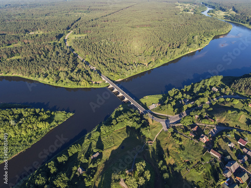 Aerial view over Merkys river valley, near Merkine town, Lithuania. During sunny summer season, surrounded by pine tree forest. photo