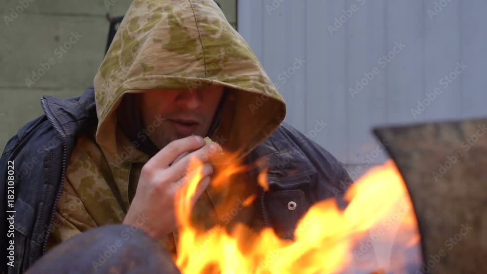 Homeless man eating by the fire clouse up Homeless man eating by the fire clouse up