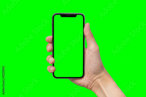 Man's hand shows mobile smartphone with green screen in vertical position isolated on green background