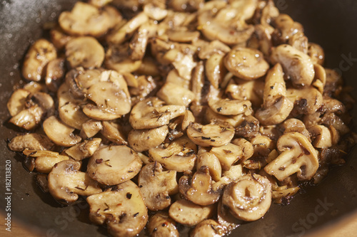 Button mushrooms frying in olive oil and garlic