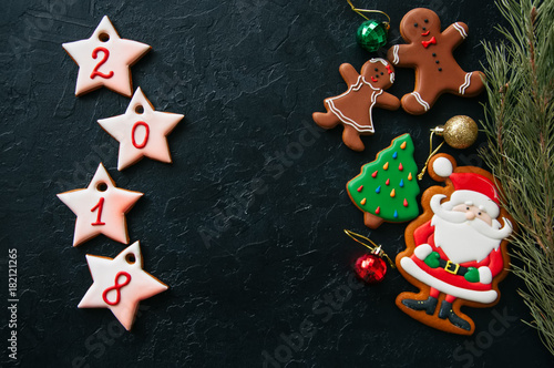 Christmas ornew year background. Different shapes of gingerbread cookies and decorations on a wooden backdrop. Copy space and top view.