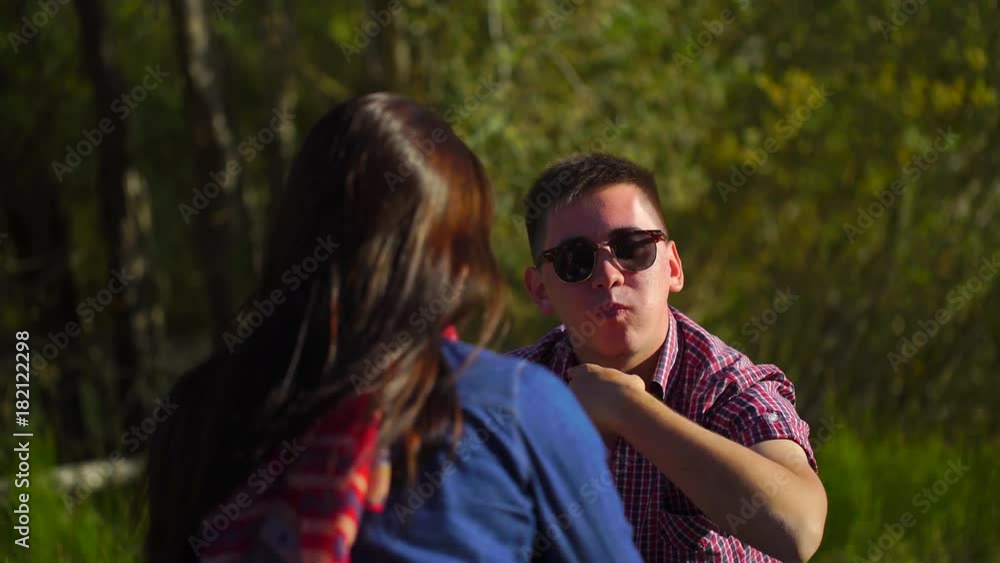 Young man and woman eating watermelon at the picnic in the forest near the river on the background of mountains. 4 k Young man and woman eating watermelon at the picnic in the forest near the river on the background of mountains. 4 k