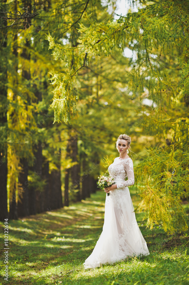 Young girl in white wedding dress standing on the background of autumn Young girl in white wedding dress standing on the background of autumn
