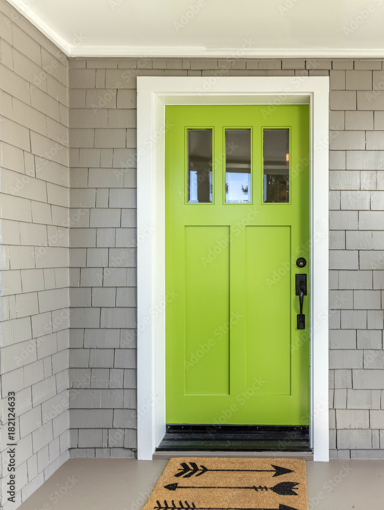 Obraz premium A front entrance of a home with a green entry door, front door & door mat