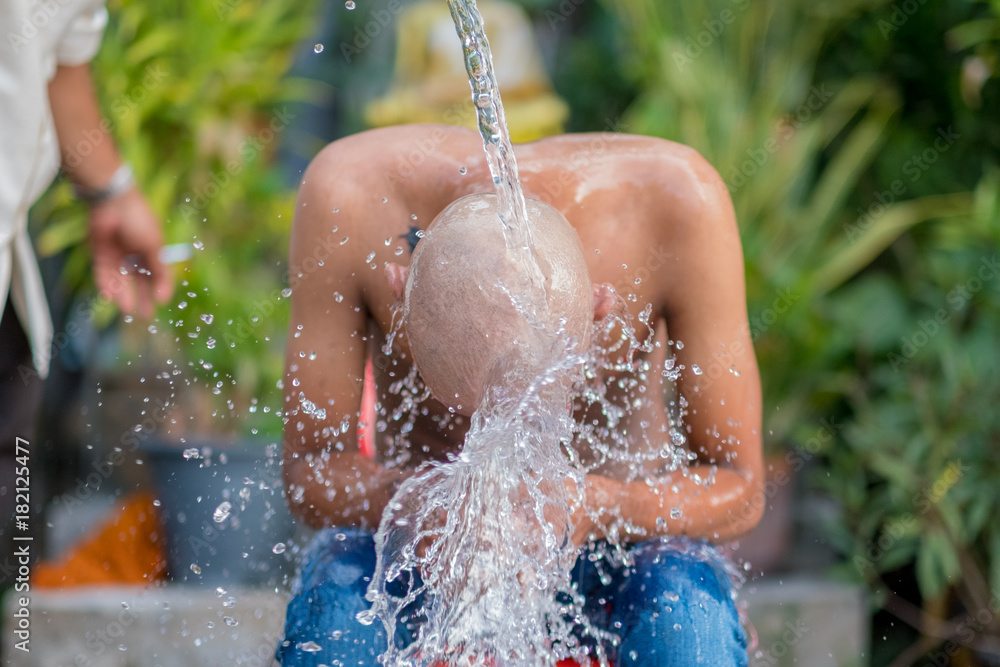 Foto de People take a shower after shave his head to a monk in