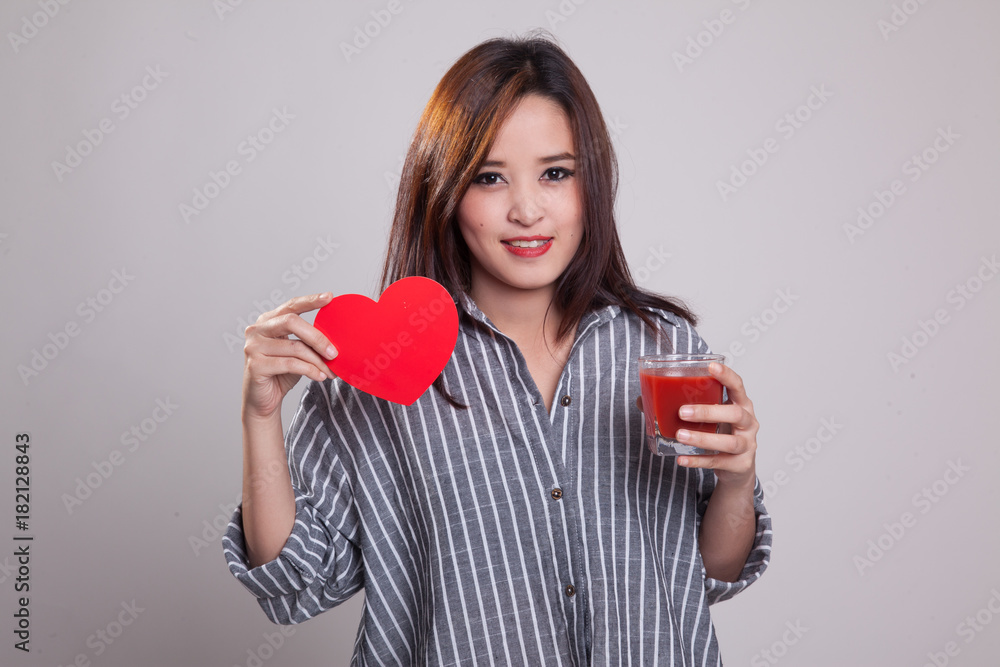 Young Asian woman with tomato juice and red heart. Young Asian woman with tomato juice and red heart.