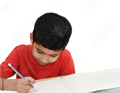 Indian kid boy drawing at home with pencil and smile isolated background