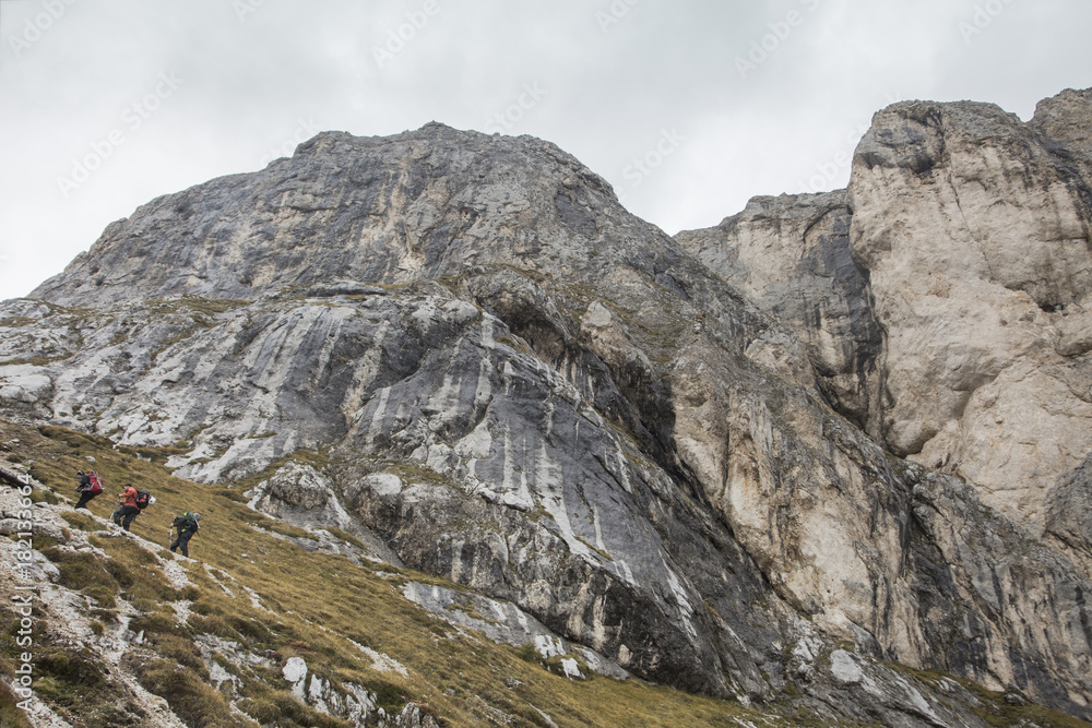 Fototapeta premium Tourist in Dolomites alps crossing rocks