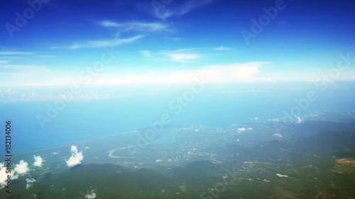 Aerial view of the blue sea coastline and green hilly country