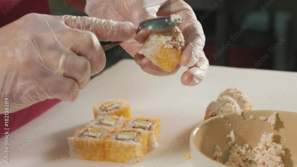 Professional sushi chef preparing roll at commercial kitchen, close-up. Professional sushi chef preparing roll at commercial kitchen, close-up.