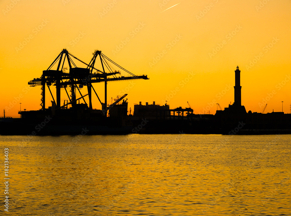 Silhouette of Lanterna (lighhouse) of city of Genoa (Genova), the symbol of the city, in the port at sunset. Italy