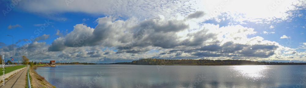 Panoramic landscape with damm, river and clouds