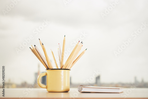 Iron mug with pencils and notepad