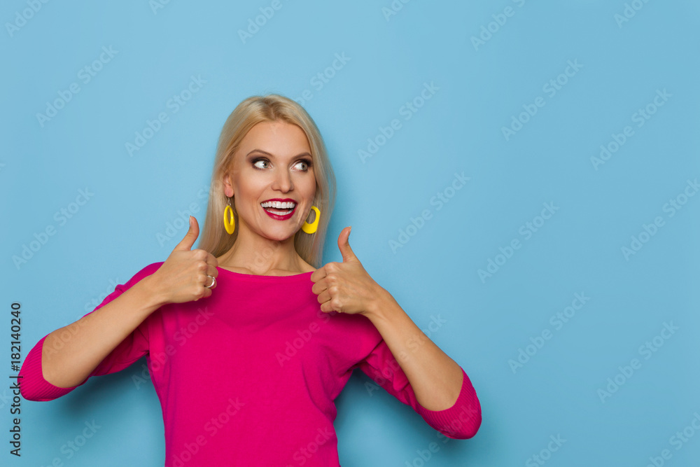 Smiling Blond Woman Is Showing Thumbs Up, Smiling And Looking Away Smiling Blond Woman Is Showing Thumbs Up, Smiling And Looking Away