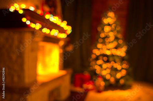 Blurred living room interior with fireplace and decorated christmas tree