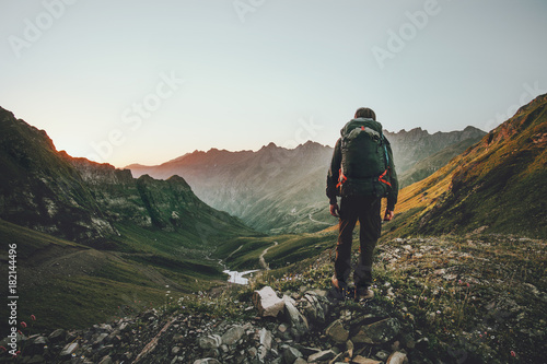 Photographie Man hiking at sunset mountains with heavy backpack Travel Lifestyle wanderlust a