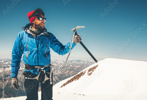 Man climber holding ice axe on mountain glacier Travel Lifestyle concept adventure active vacations extreme outdoor mountaineering sport using alpinism equipment photo
