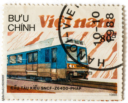 Old postage stamp with blue electric locomotive and railway, printed in Vietnam in 1988