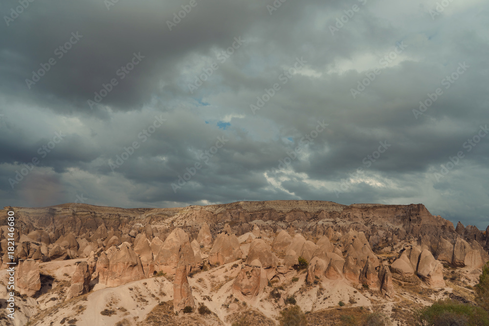 rocky landscape in cloudy weather, rain and sun in canyon