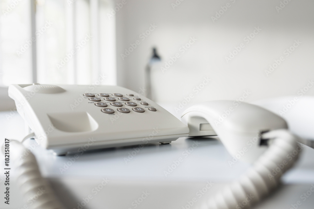 Classical white landline telephone with receiver off the hook Classical white landline telephone with receiver off the hook