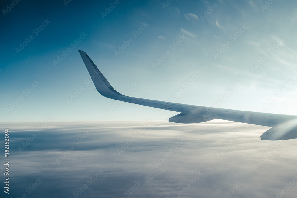 Fototapeta premium Airplain wing view thrue porthole in the sky