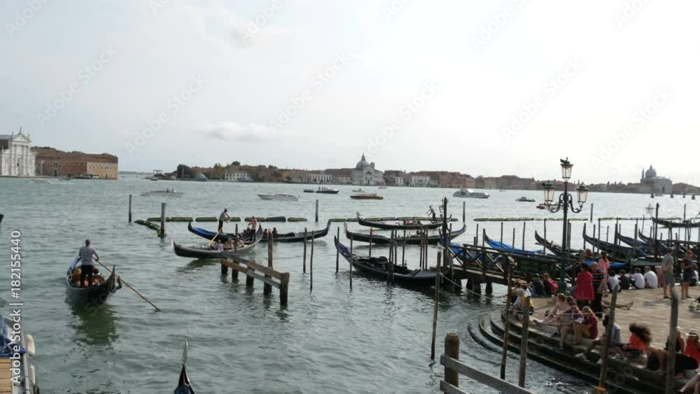 VENICE, ITALY, SEPTEMBER 7, 2017: View of the grand canal on which the gondolas with tourists go, the embankment on which people rest