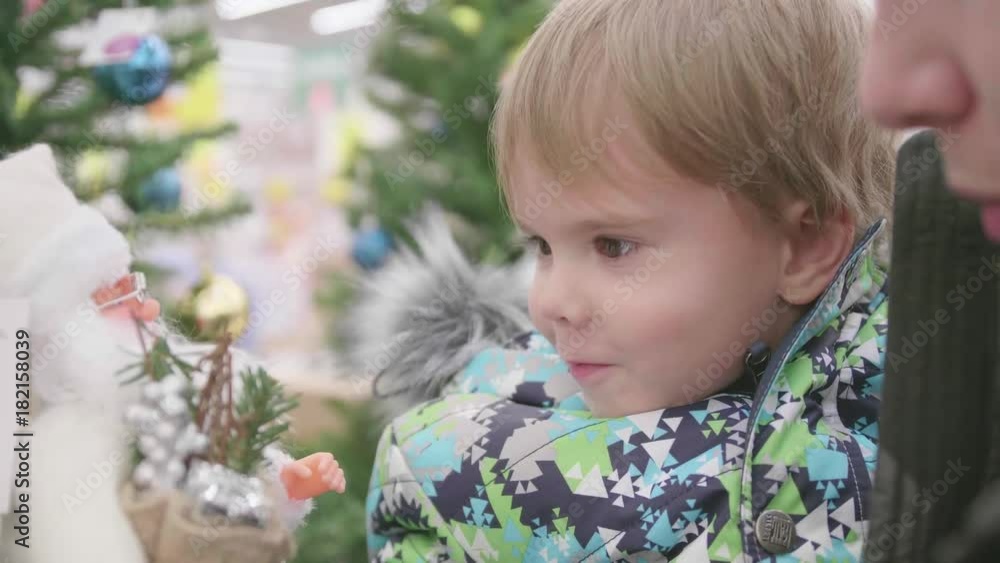 Father and son choose a Christmas gift in the store. Christmas sale of toys and Christmas trees until Christmas. Christmas gifts for loved ones Father and son choose a Christmas gift in the store. Christmas sale of toys and Christmas trees until Christmas. Christmas gifts for loved ones