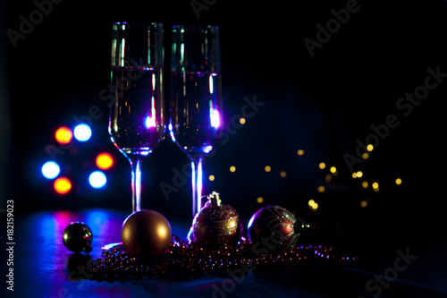 two champagne glasses with christmas lights and decorations