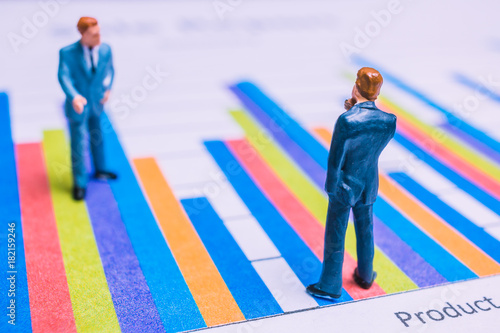 Miniature People : Businessman standing on a Paper graph chart ,Developing a teamwork concept