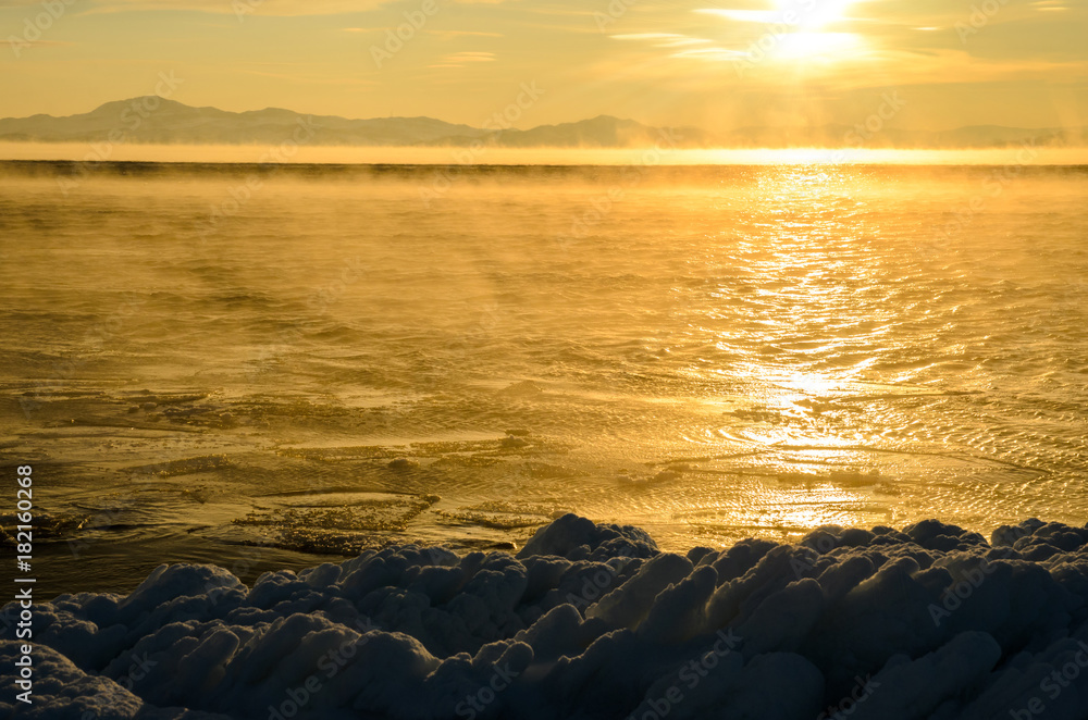 Obraz premium Ice floes floating on the fog water in the lake Baikal. Sunset