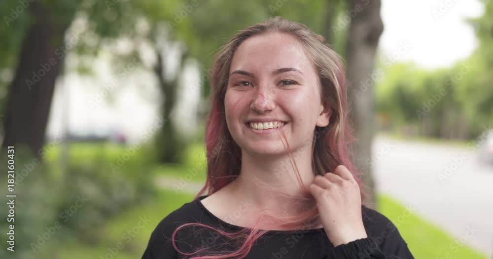 Slow motion handheld shot of happy teen girl having fun with purple hair standing in town Slow motion handheld shot of happy teen girl having fun with purple hair standing in town