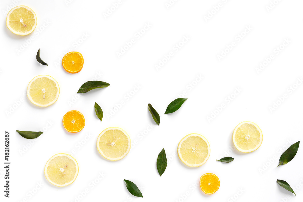  Pattern of fresh fruits on a white background, top view, flat lay. Composition of green leaves and slices of citrus fruits: lemon, mandarin. Healthy food background, wallpaper, collage.