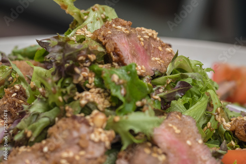 Close up Roasted beef with herbed bread crust sliced and vegetable. (selective focus) photo