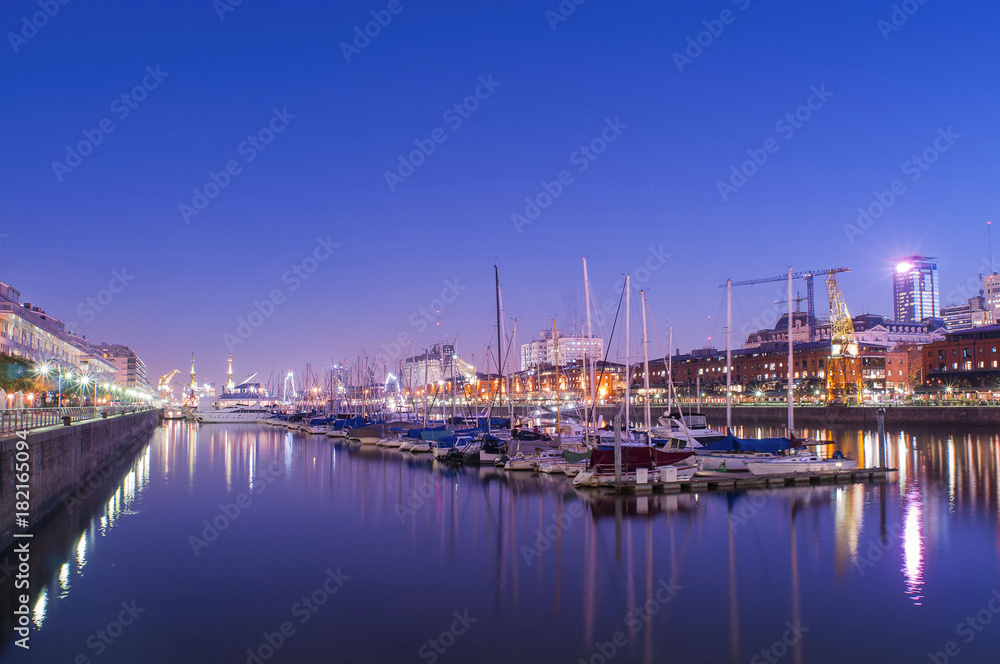 boats and buildings in city at night