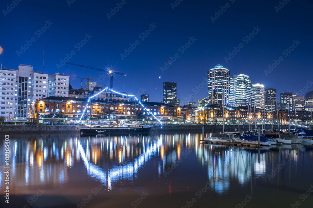boats and buildings in city at night