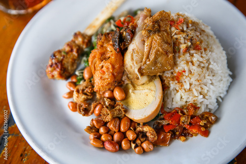 spicy balinese nasi campur with ice tea photo