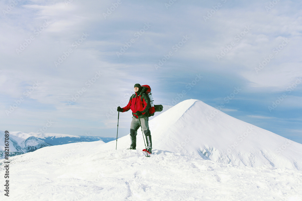 Winter hike in the mountains with a backpack and tent.