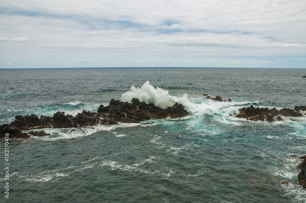 Beautiful color of Atlantic Ocean, waves and rocks in Porto Moniz, Madeira, Portugal 