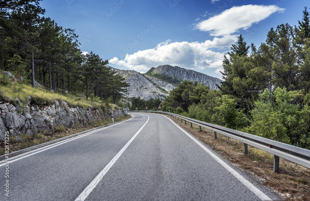 Country road through the rocky mountains and forest. Country road through the rocky mountains and forest.