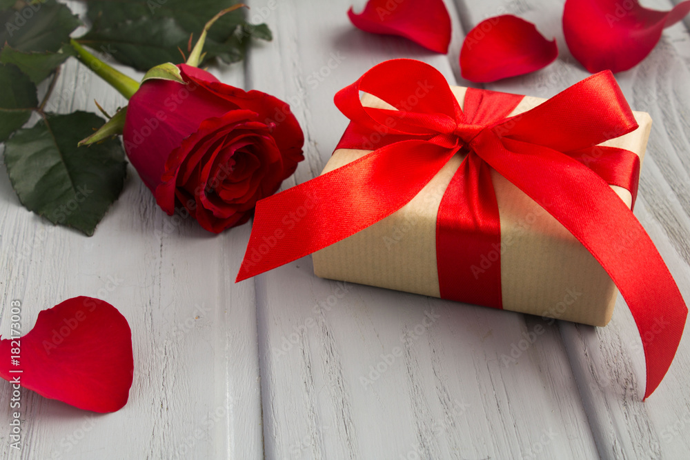 Gift box,red rose and petals on the grey wooden background Gift box,red rose and petals on the grey wooden background