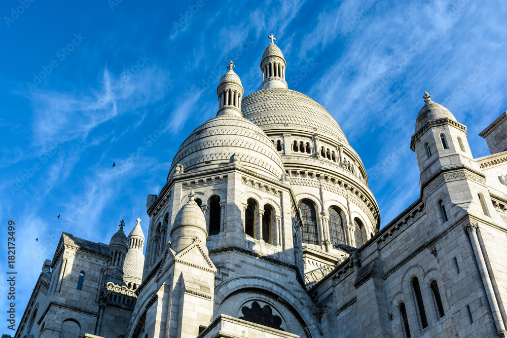 Low angle view of the dome of the Basilica of the Sacred Heart of Paris against blue sky.