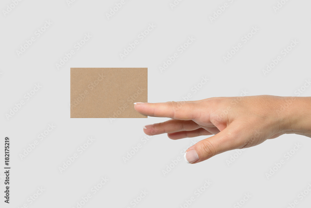Mockup of female hand holding a Kraft Paper Business Card isolated on light grey background. Size 85 × 55 mm. Mockup of female hand holding a Kraft Paper Business Card isolated on light grey background. Size 85 × 55 mm.