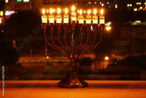 image of jewish holiday Hanukkah background with menorah (traditional candelabra) and burning candles