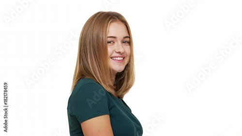 Half-turned portrait of charming young woman with playful look shrugging being embarrassed feeling shyness posing over white background. Concept of emotions