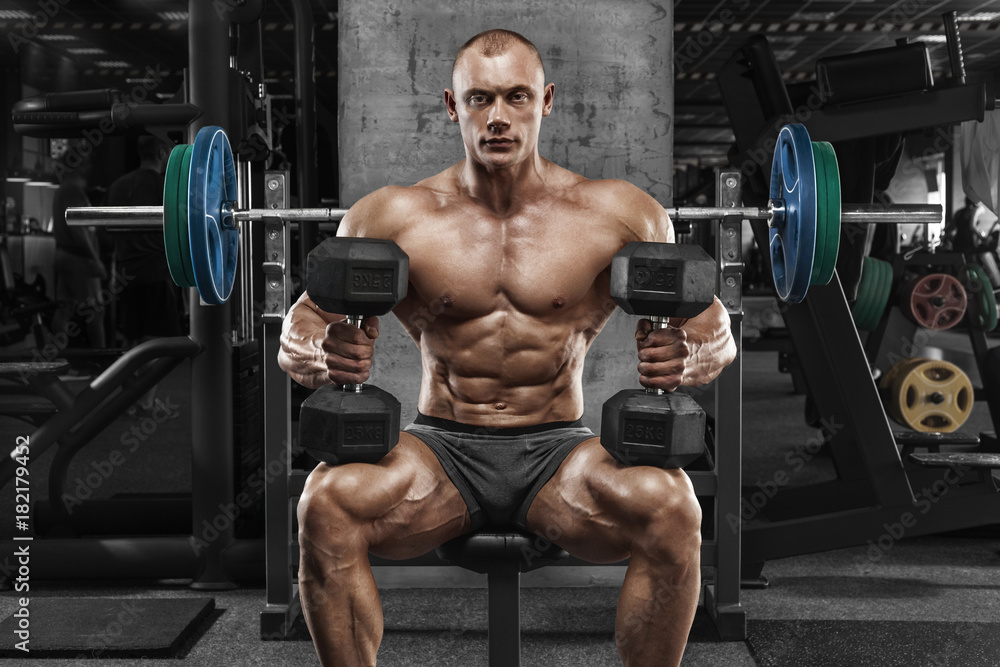 Muscular man with dumbbells in gym, bodybuilder. Strong male naked torso abs, working out Muscular man with dumbbells in gym, bodybuilder. Strong male naked torso abs, working out