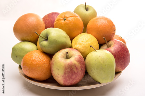 Tasty fruit orange, apples and lemon on the wooden plate
