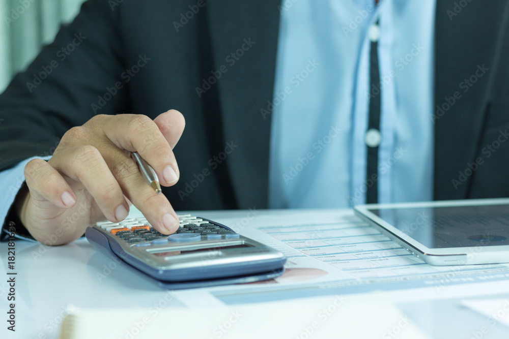 Fototapeta premium business people who use a calculator with financial concepts, spreadsheet data, business people use their fingers to compute calculations for sales graphs and more storage space.